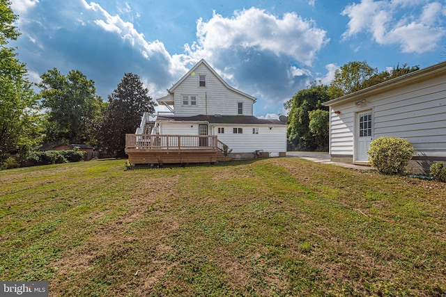 back of house featuring a wooden deck and a lawn