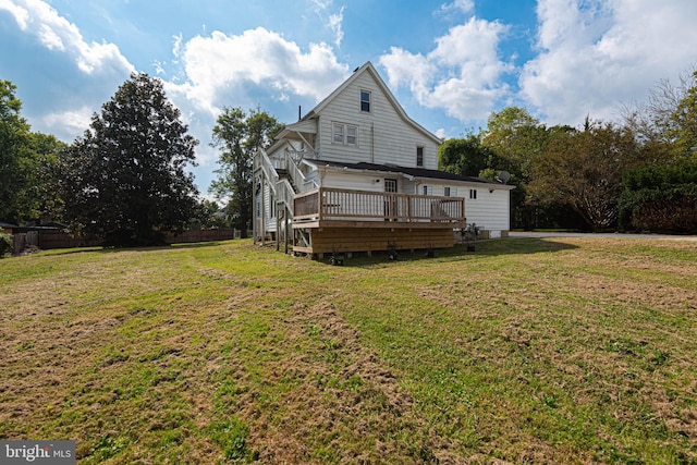 rear view of house with a yard and a wooden deck