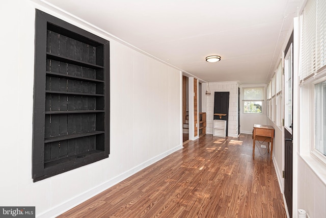 hallway with built in features and hardwood / wood-style flooring