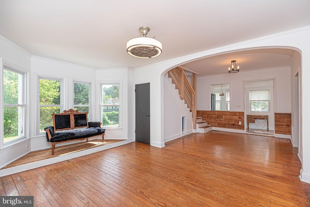 interior space with wooden walls, plenty of natural light, hardwood / wood-style floors, and crown molding