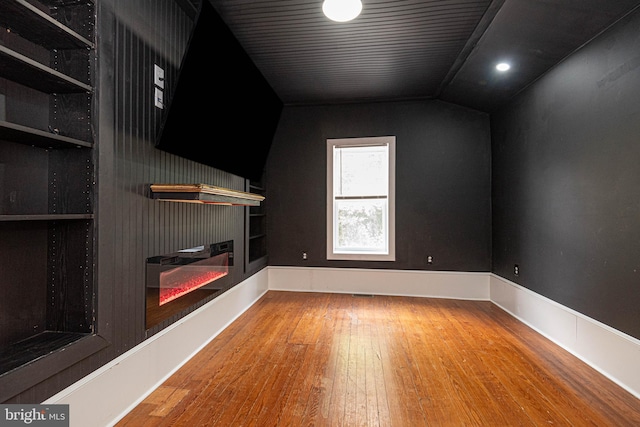 unfurnished living room featuring vaulted ceiling and hardwood / wood-style floors