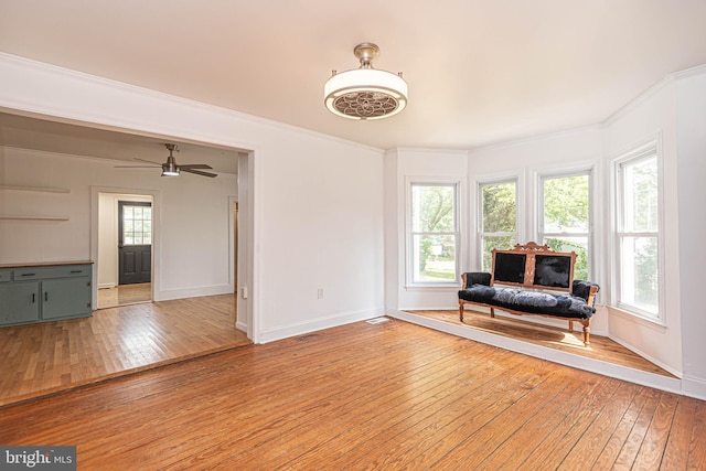 unfurnished room featuring ornamental molding, light wood-type flooring, and ceiling fan