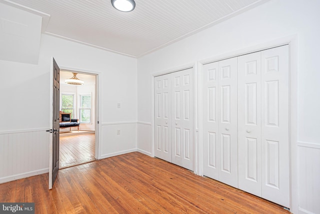 unfurnished bedroom featuring hardwood / wood-style flooring and two closets