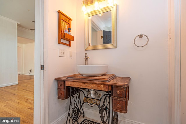 bathroom with vanity, crown molding, and hardwood / wood-style floors