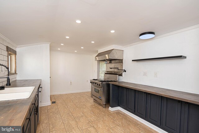 kitchen with wall chimney exhaust hood, stainless steel range, crown molding, sink, and butcher block countertops