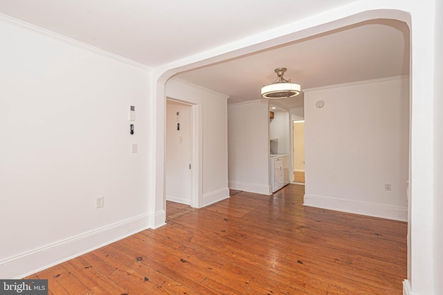 empty room featuring wood-type flooring and ornamental molding