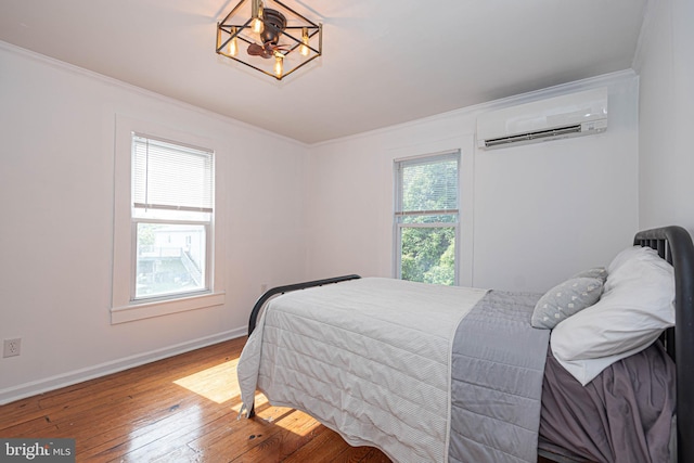 bedroom featuring ornamental molding, hardwood / wood-style floors, a wall mounted AC, and a notable chandelier