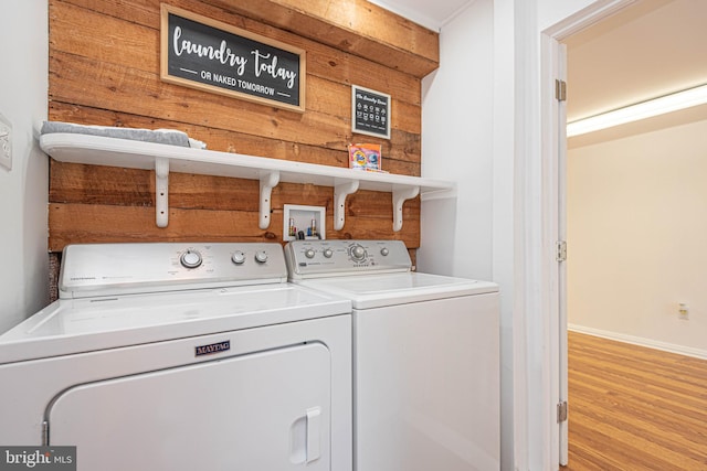 washroom with washer and clothes dryer and light hardwood / wood-style floors