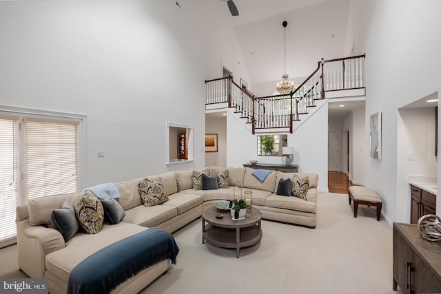 living room with carpet floors, a chandelier, and high vaulted ceiling