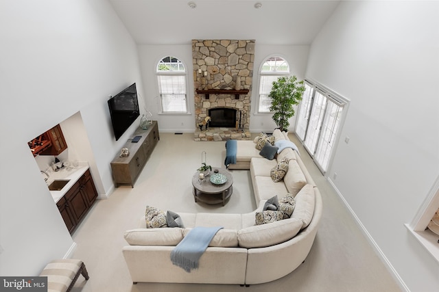 carpeted living room featuring a fireplace and sink