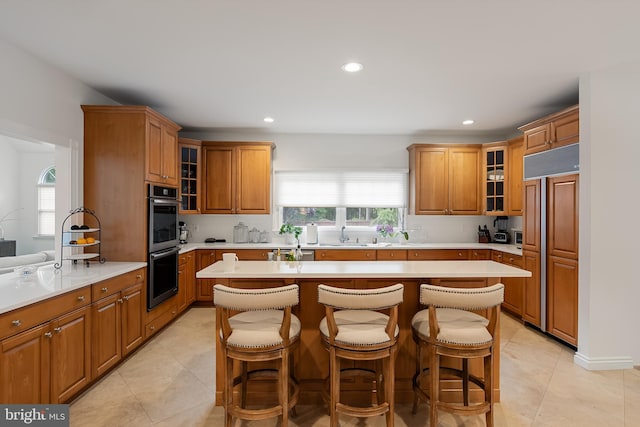 kitchen with a breakfast bar, stainless steel appliances, light tile patterned flooring, and a kitchen island