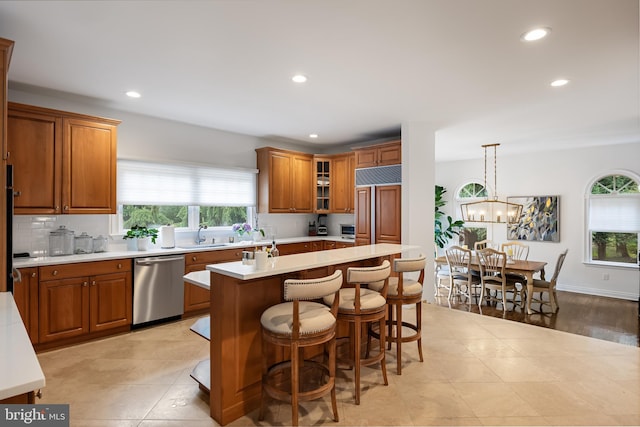 kitchen featuring a kitchen island, an inviting chandelier, light hardwood / wood-style flooring, decorative light fixtures, and stainless steel dishwasher