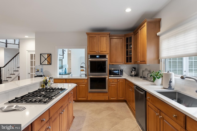 kitchen with appliances with stainless steel finishes, backsplash, and sink