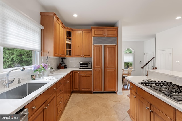 kitchen featuring paneled refrigerator, stainless steel gas cooktop, sink, and a wealth of natural light