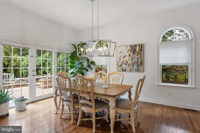 dining area featuring a chandelier, french doors, and hardwood / wood-style flooring