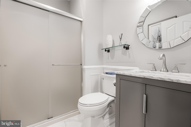 bathroom with walk in shower, vanity, and toilet