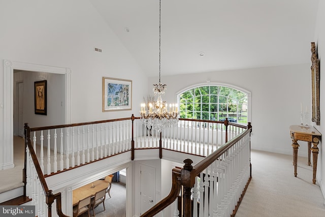 interior space with a notable chandelier, light carpet, and high vaulted ceiling