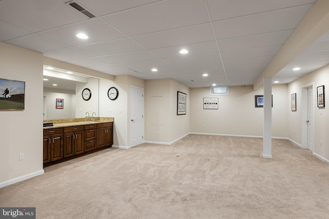 basement with light carpet and a drop ceiling