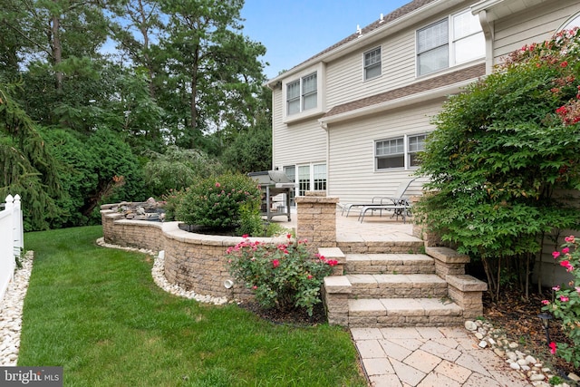 back of property with a yard and a patio area