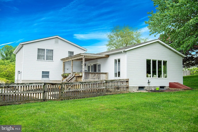 rear view of property featuring a wooden deck and a lawn