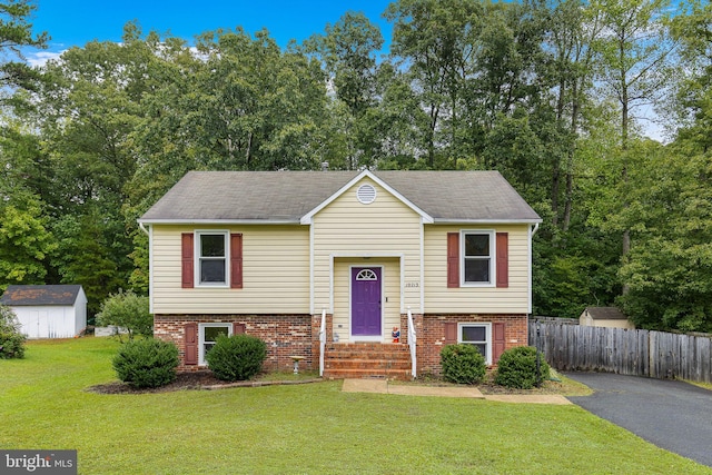 bi-level home featuring a storage shed and a front lawn