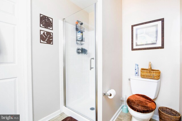 bathroom with a shower with shower door and toilet