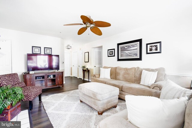 living room featuring dark wood-type flooring and ceiling fan