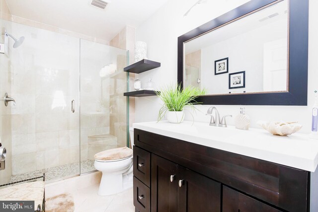 bathroom featuring tile patterned flooring, an enclosed shower, vanity, and toilet