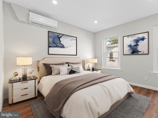 bedroom with dark hardwood / wood-style flooring and a wall unit AC