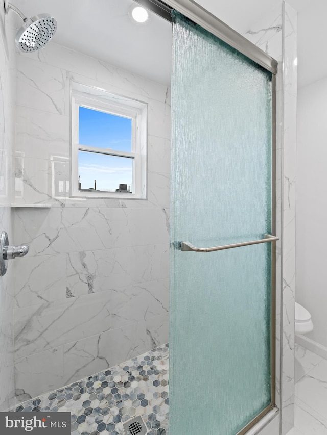 bathroom featuring toilet and an enclosed shower