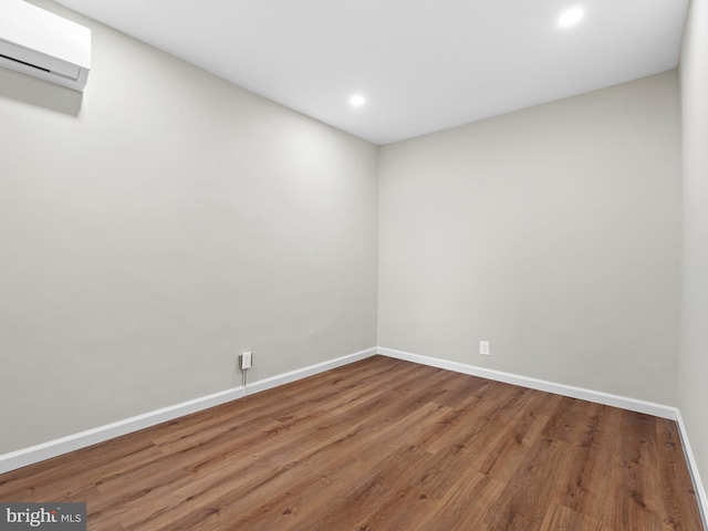 spare room with hardwood / wood-style floors and a wall mounted air conditioner