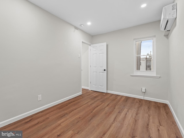 empty room featuring light hardwood / wood-style floors and a wall mounted AC