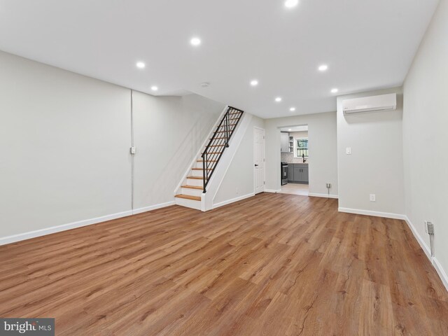 interior space with light hardwood / wood-style flooring and a wall mounted AC