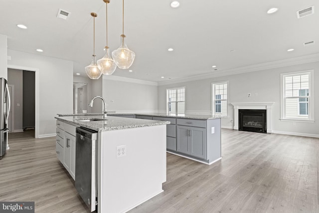 kitchen featuring appliances with stainless steel finishes, a center island with sink, plenty of natural light, and sink