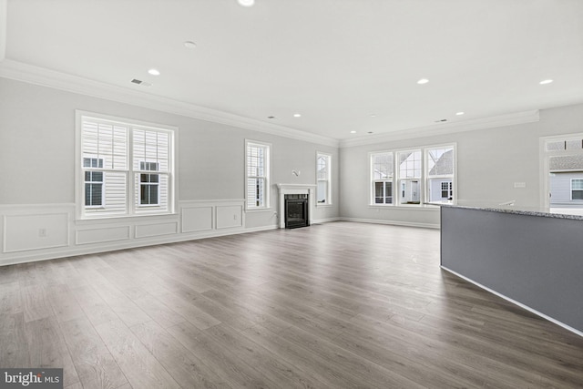 unfurnished living room featuring ornamental molding and hardwood / wood-style flooring