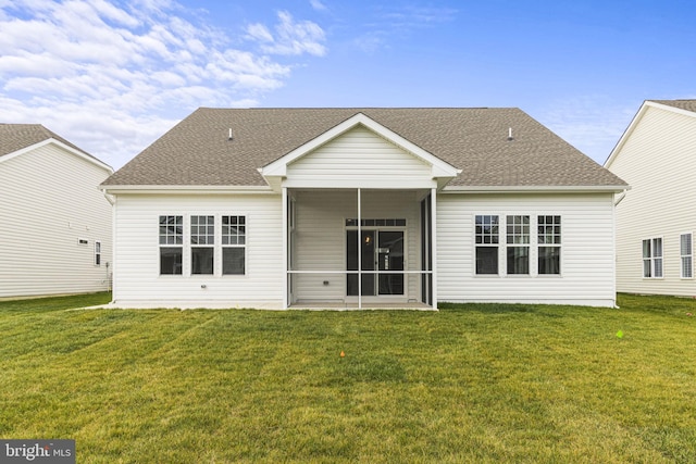 rear view of house with a sunroom and a lawn