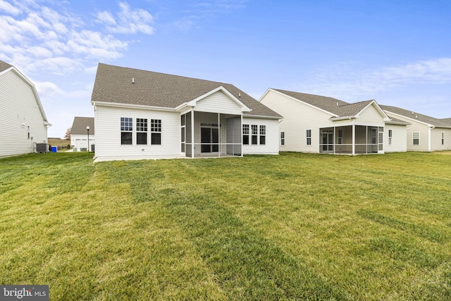 rear view of property featuring a sunroom, central air condition unit, and a lawn