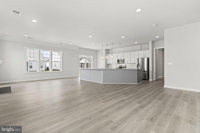 unfurnished living room with light wood-type flooring, crown molding, and sink