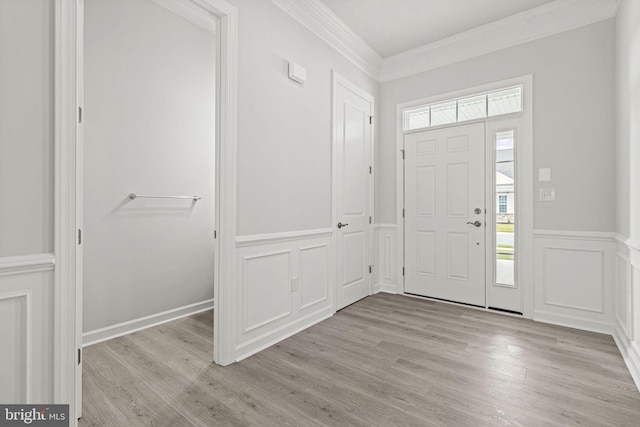 entryway featuring light wood-type flooring, crown molding, and a wealth of natural light