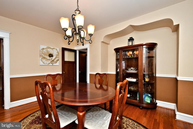 dining space with a notable chandelier and dark hardwood / wood-style flooring