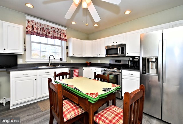 kitchen with white cabinetry, stainless steel appliances, sink, ceiling fan, and dark wood-type flooring