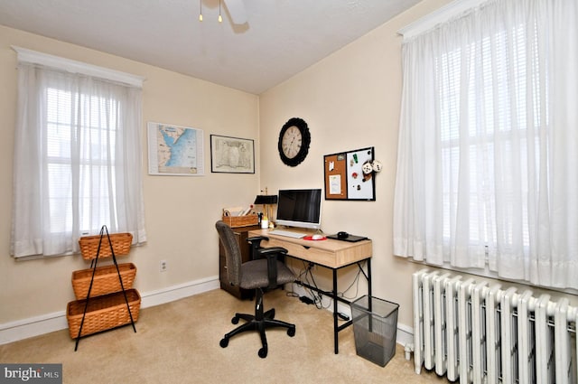 carpeted office space with ceiling fan and radiator heating unit