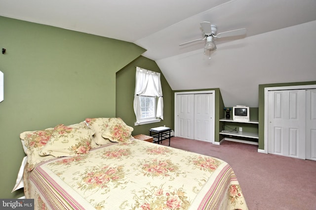 bedroom featuring ceiling fan, multiple closets, vaulted ceiling, and carpet floors