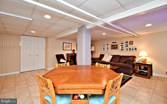 dining space with light tile patterned floors and a paneled ceiling