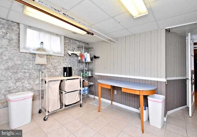 basement with light tile patterned floors and a paneled ceiling