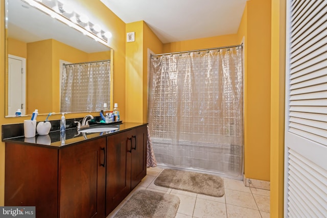 bathroom with walk in shower, vanity, and tile patterned floors