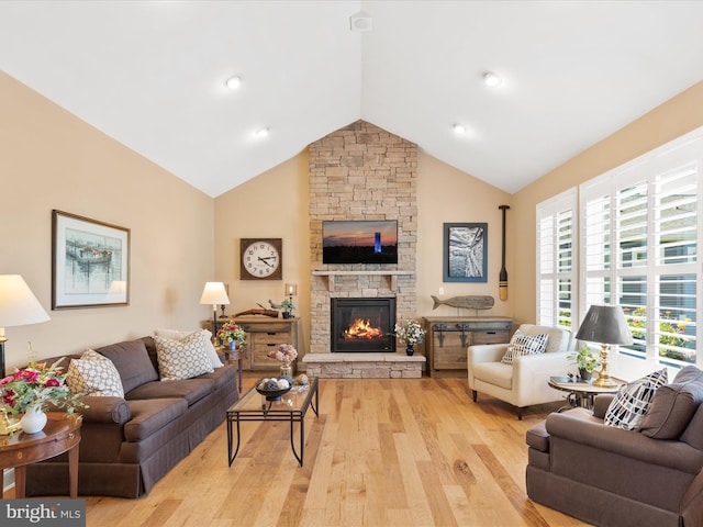 living room featuring light wood-type flooring, lofted ceiling, and a fireplace