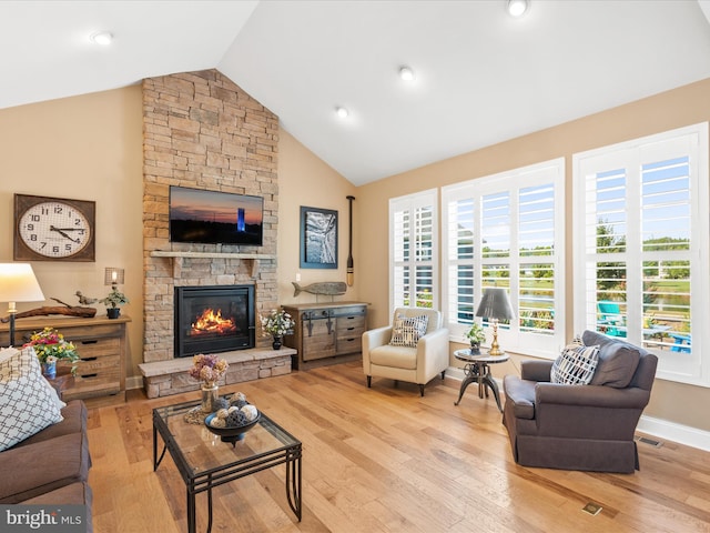 living room featuring a fireplace, light wood-type flooring, and lofted ceiling