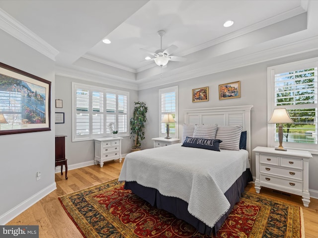 bedroom with ornamental molding, light wood-type flooring, and multiple windows