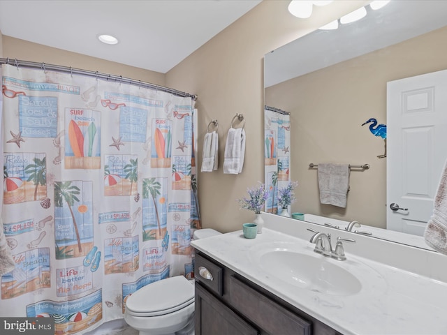 bathroom featuring walk in shower, vanity, and toilet